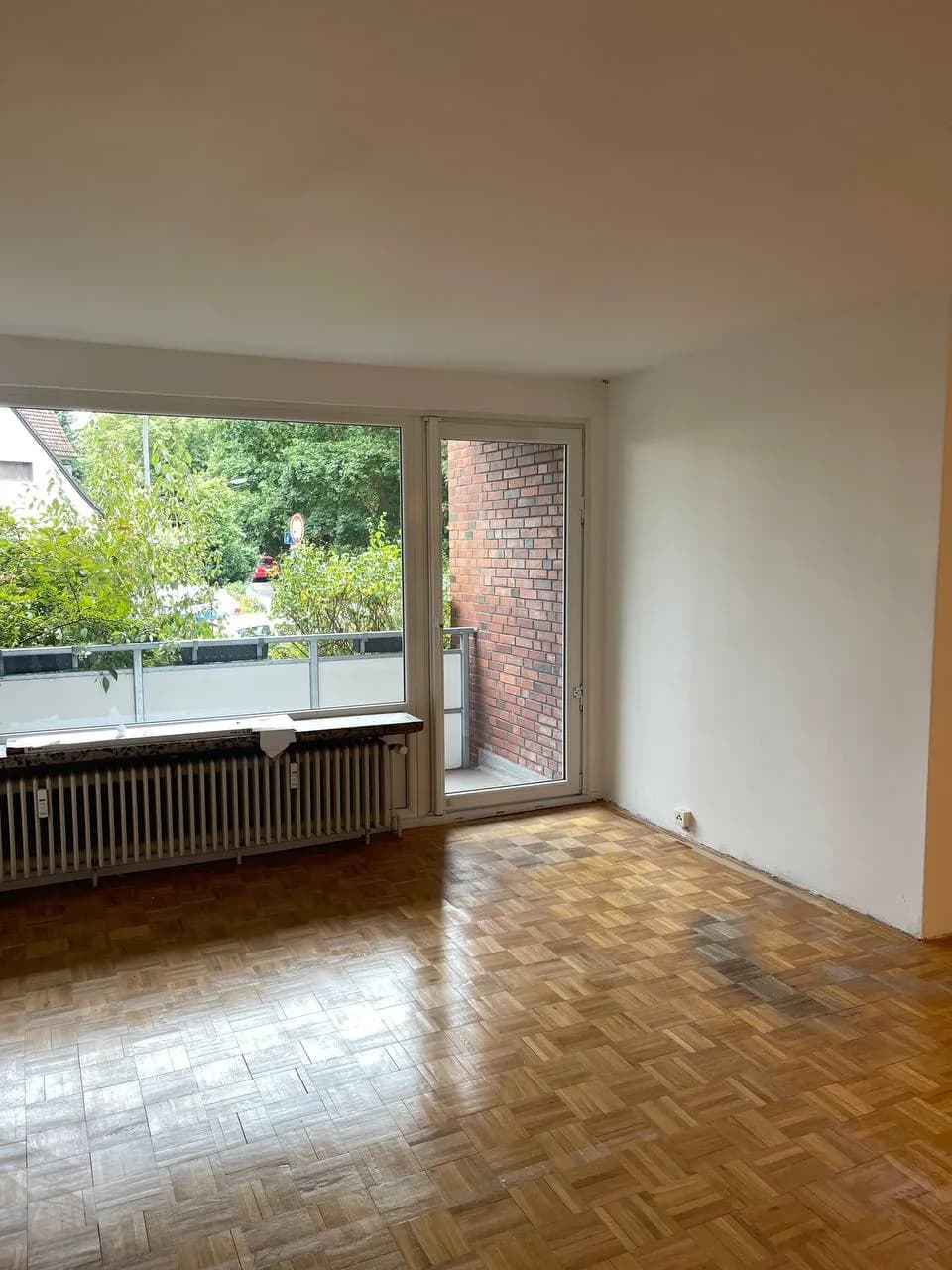 Leeres Wohnzimmer mit Balkontür in Wedel nach der Wohnungsauflösung